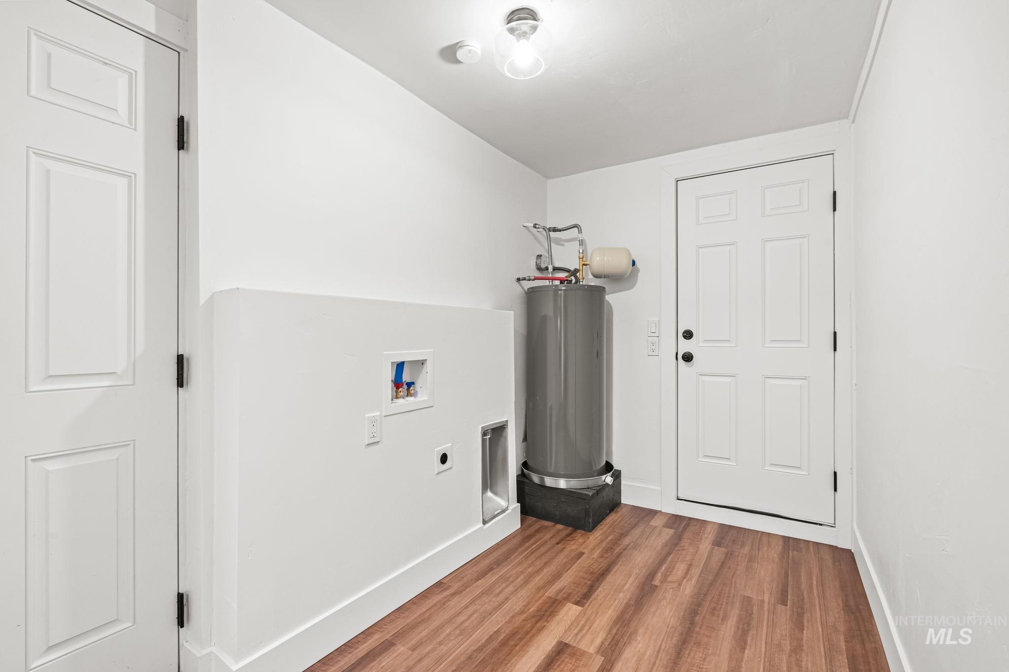 5420 Anna Street Boise, ID 83705 - Photo 15 of 24 Laundry room with wood finished floors, hookup for a washing machine, water heater, and hookup for an electric dryer