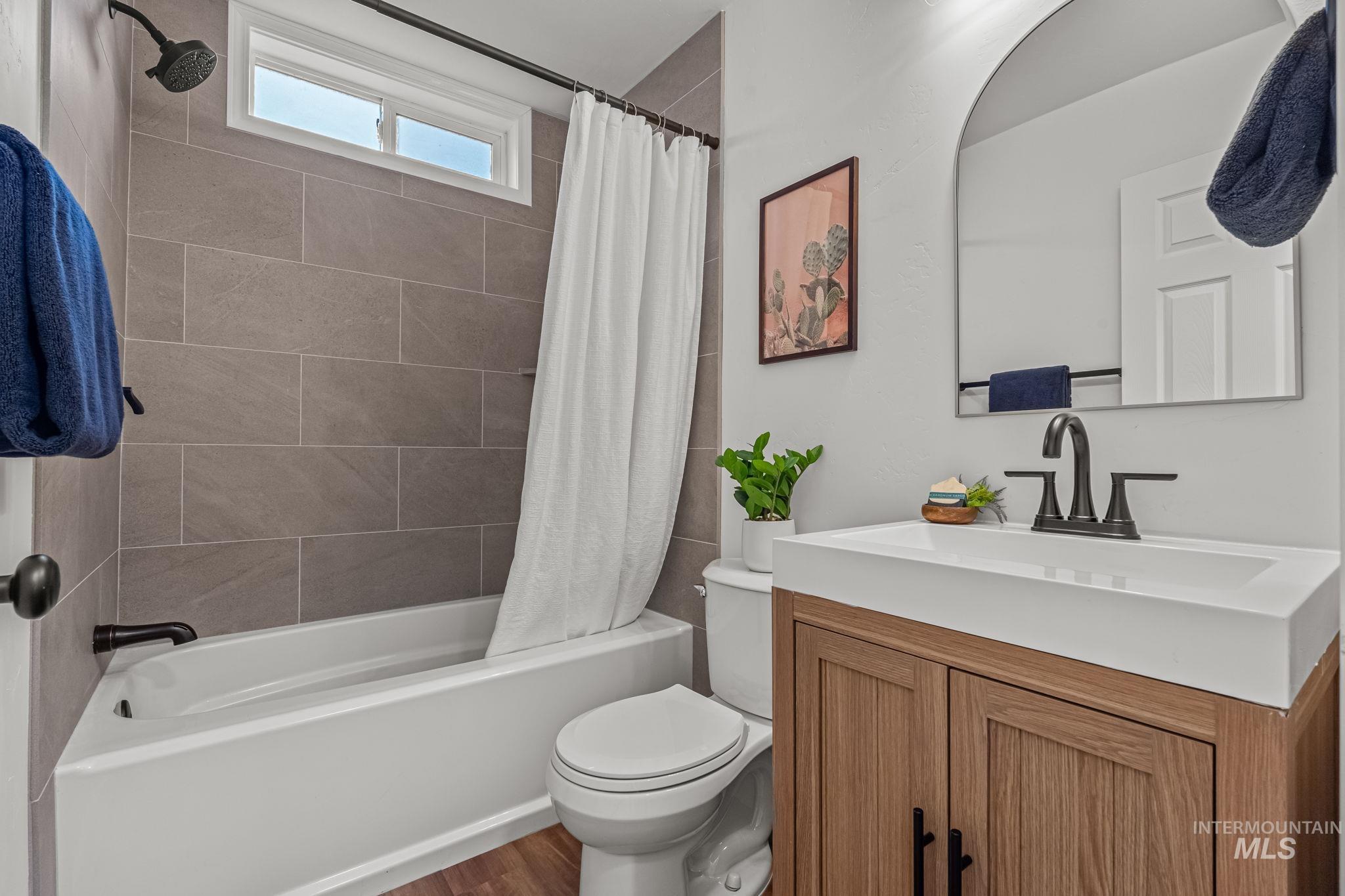 5420 Anna Street Boise, ID 83705 - Photo 19 of 24 Full bathroom with vanity, shower / bath combination with curtain, and wood finished floors