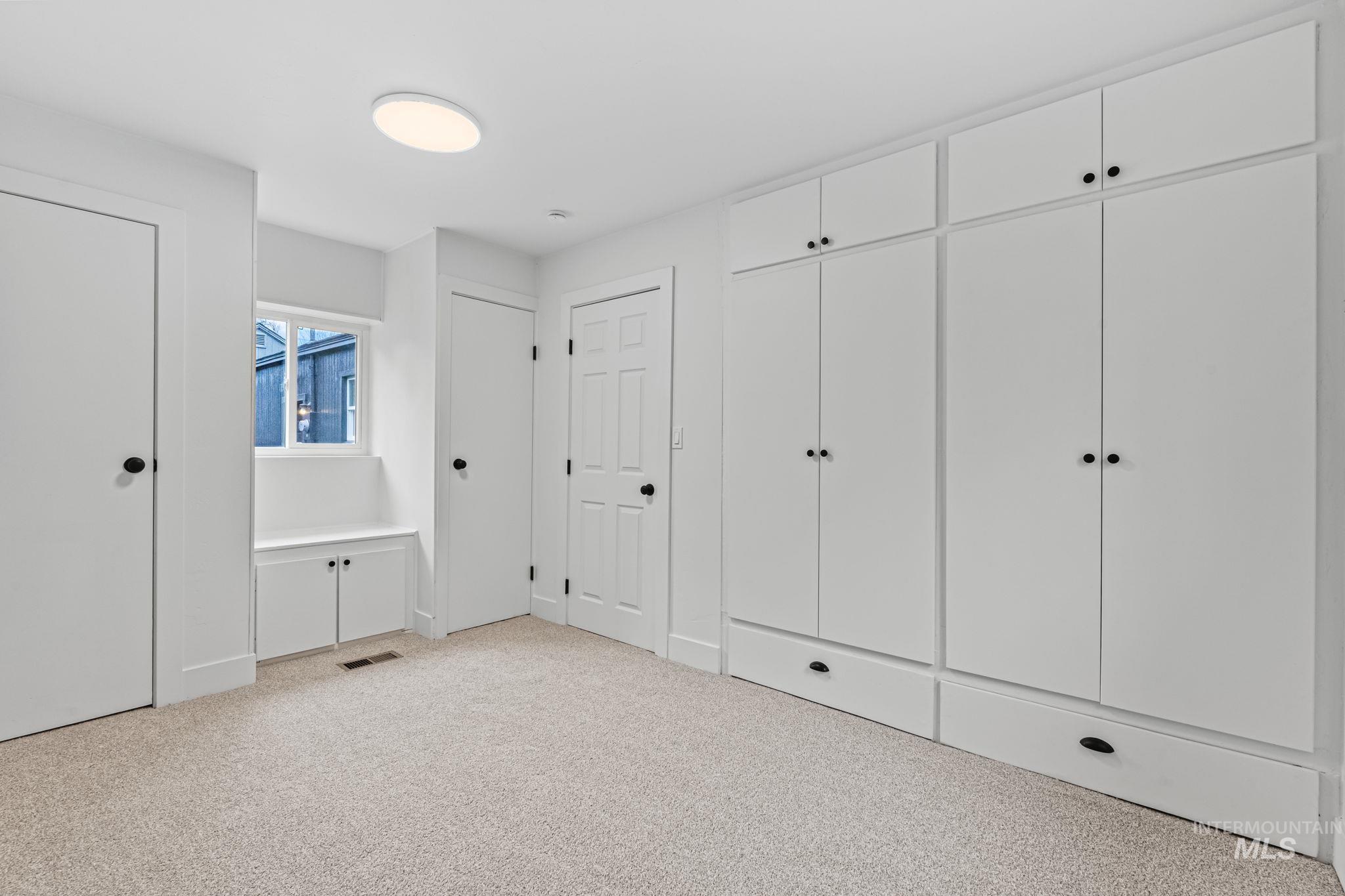 5420 Anna Street Boise, ID 83705 - Photo 20 of 24 Unfurnished bedroom with light colored carpet and two closets