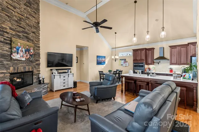 a living room with furniture a flat screen tv and kitchen view