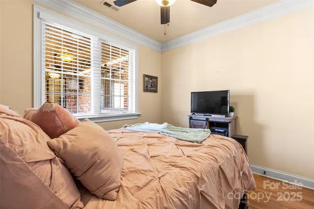 a bedroom with a bed a flat screen tv and a chandelier
