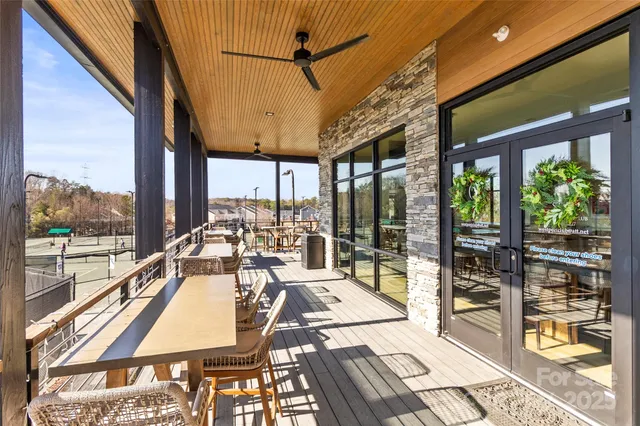 a view of a patio with lawn chairs floor to ceiling window with wooden floor