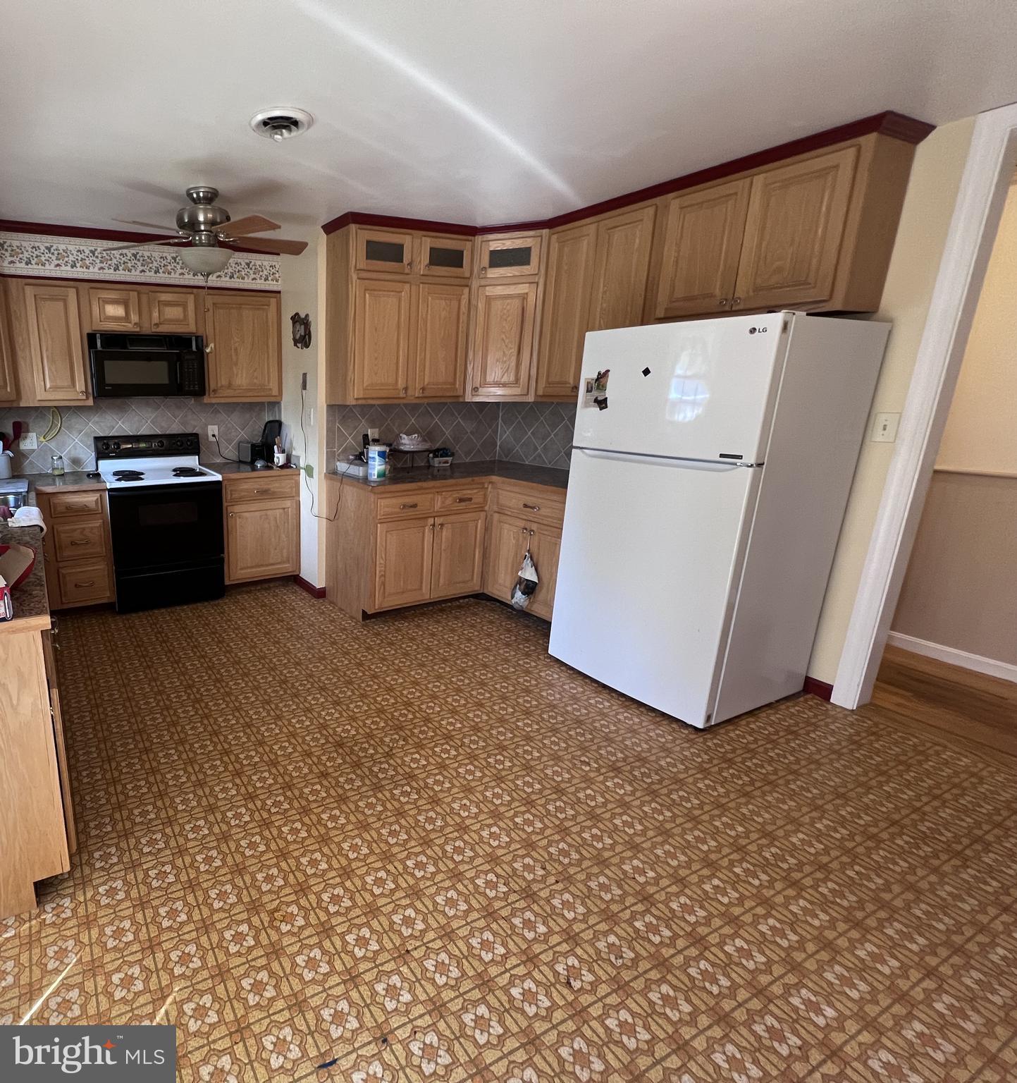 7119 Academy Road Warrenton, VA 20187 - Photo 3 of 21 a kitchen with a refrigerator and a stove top oven