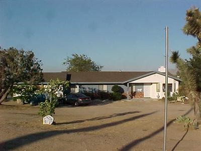 16150 Ranchero Street Hesperia, CA 92345 - Photo 1 of 1 a blue sign that is sitting in front of a house
