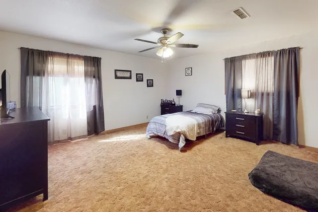 a spacious bedroom with a bed and a chandelier