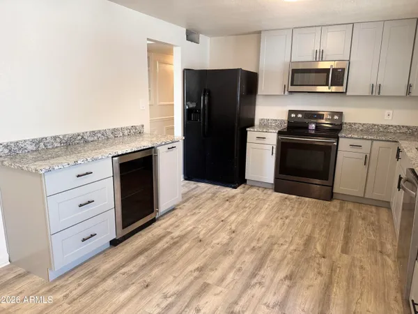 a kitchen with granite countertop a refrigerator stove and microwave