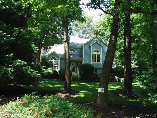 a view of a yard in front of house and trees