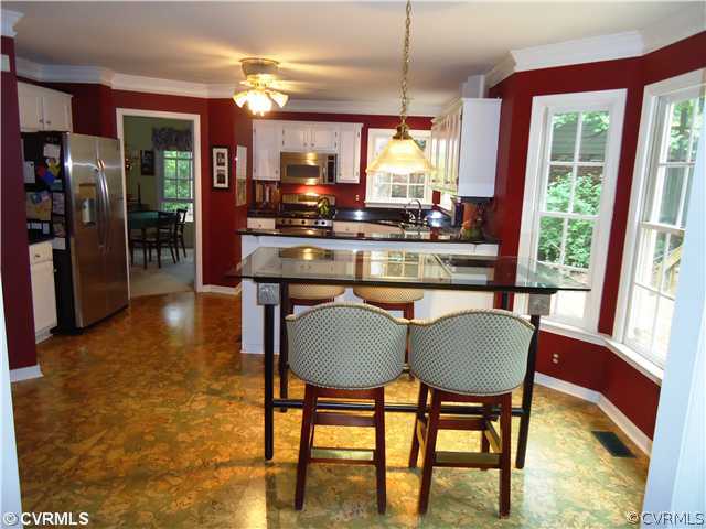 12600 Queensgate Road Midlothian, VA 23114 - Photo 2 of 7 a kitchen with stainless steel appliances granite countertop a table chairs and a refrigerator