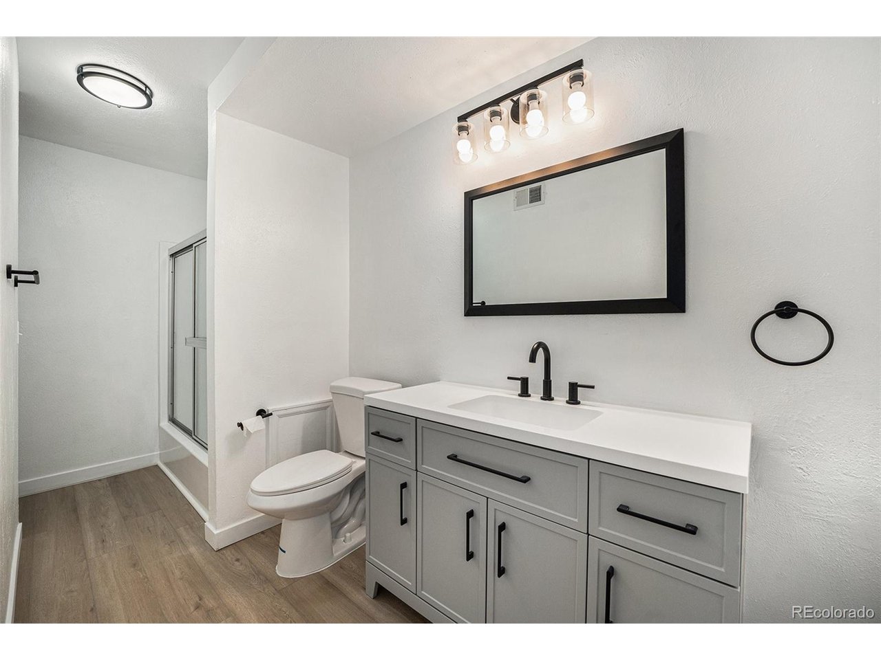 16259 West 10th Avenue, Unit K Golden, CO 80401 - Photo 10 of 24 a bathroom with a toilet sink vanity and mirror