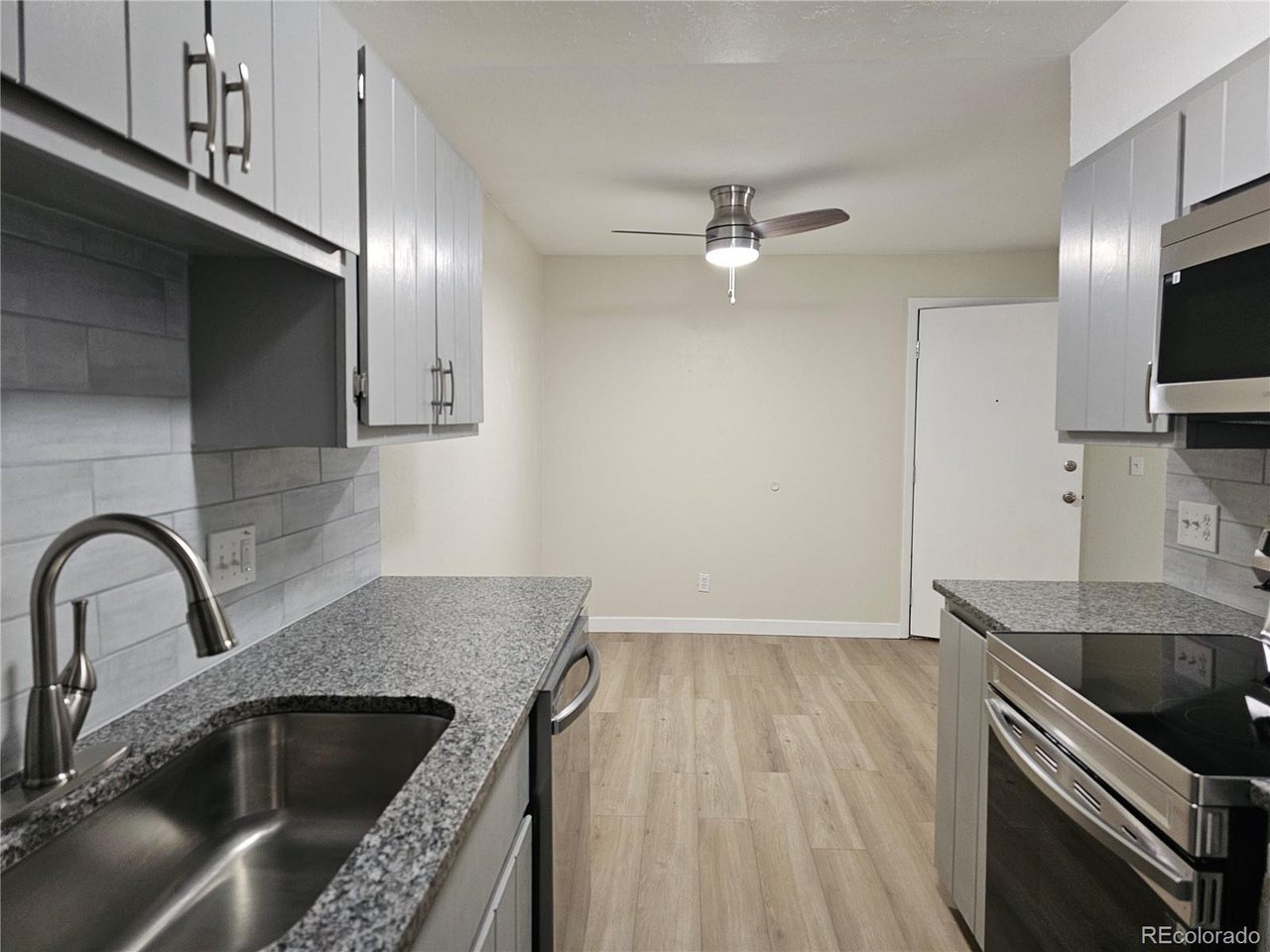 16259 West 10th Avenue, Unit K Golden, CO 80401 - Photo 6 of 24 a kitchen with granite countertop a sink stainless steel appliances and cabinets