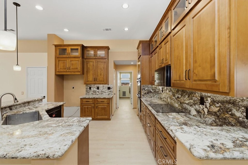 13747 Robinbrook Court Eastvale, CA 92880 - Photo 18 of 50 a large kitchen with stainless steel appliances granite countertop a sink stove and cabinets