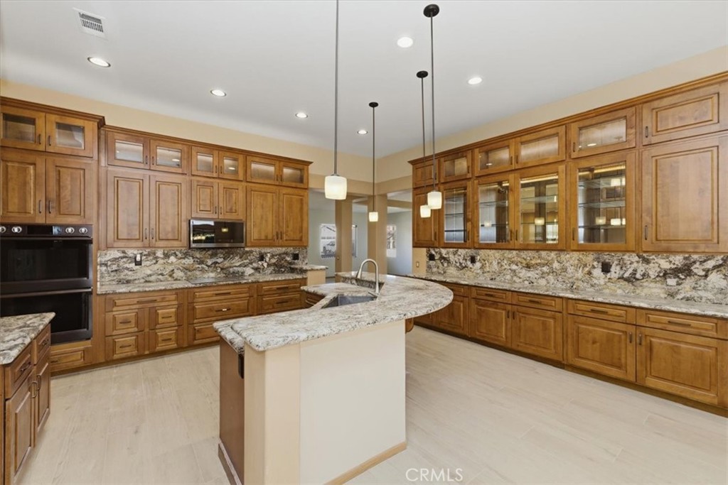 13747 Robinbrook Court Eastvale, CA 92880 - Photo 20 of 50 a large kitchen with stainless steel appliances granite countertop a stove and cabinets