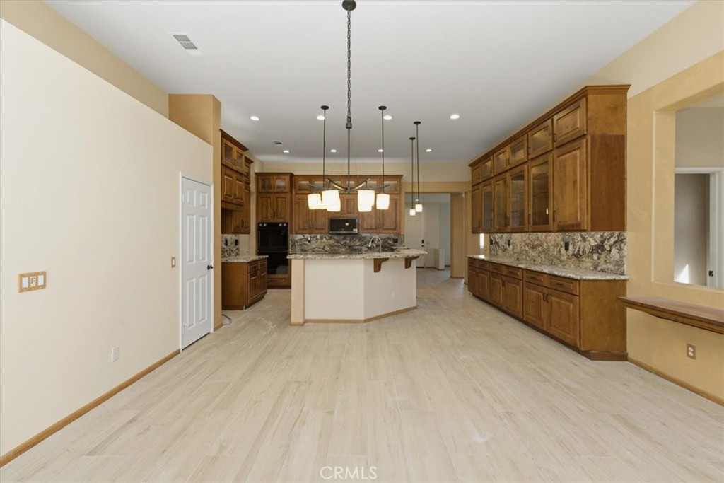 13747 Robinbrook Court Eastvale, CA 92880 - Photo 24 of 50 a large white kitchen with a large window and stainless steel appliances