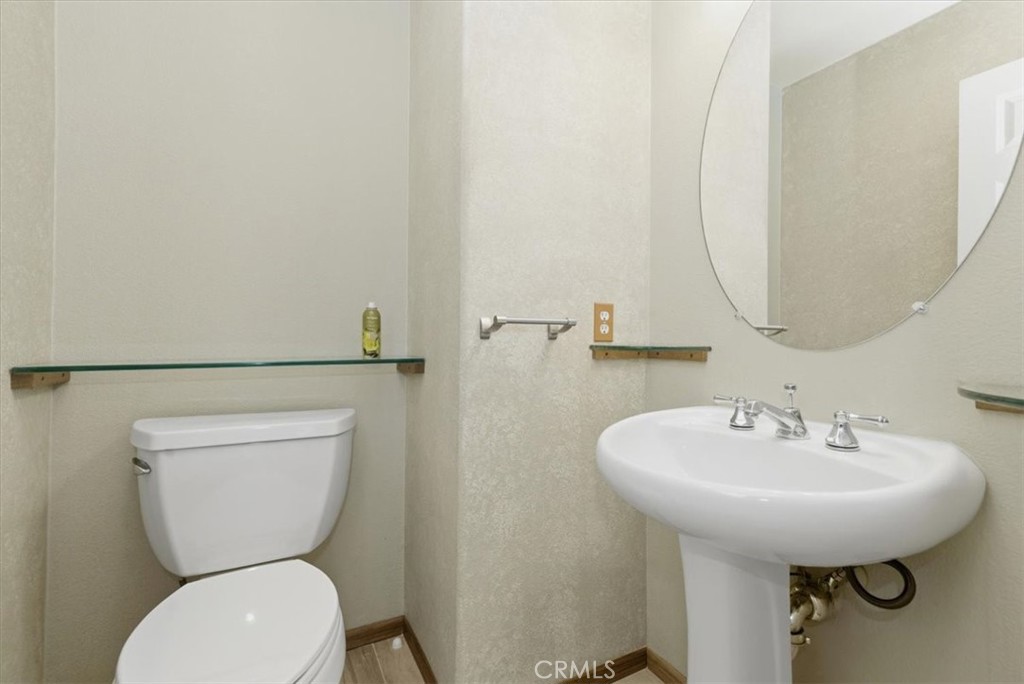 13747 Robinbrook Court Eastvale, CA 92880 - Photo 35 of 50 a bathroom with a toilet a sink and a mirror