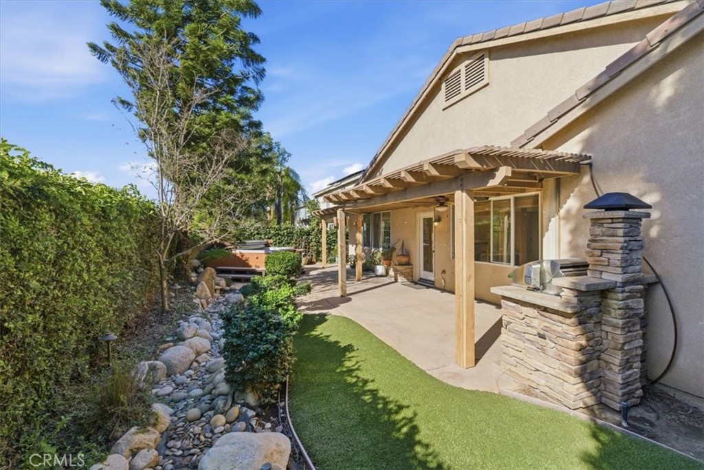 13747 Robinbrook Court Eastvale, CA 92880 - Photo 45 of 50 a view of a house with backyard sitting area and garden