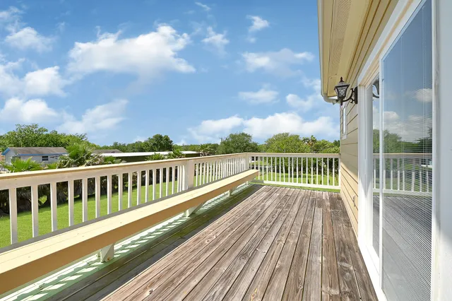 a view of balcony with wooden floor and fence