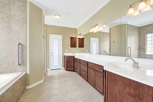 a spacious bathroom with a granite countertop sink mirror and a bathtub