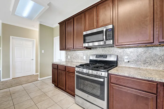 a kitchen with stainless steel appliances granite countertop a stove microwave and cabinets