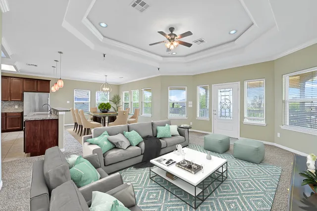 a living room with furniture ceiling fan and a window