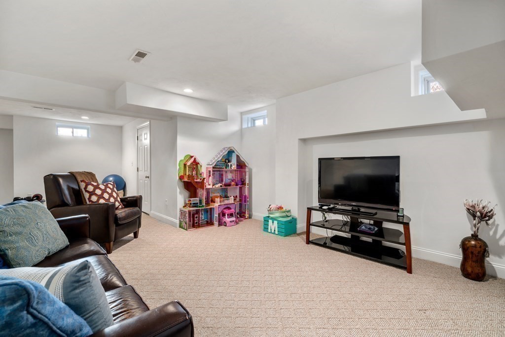 48 Mohawk Path Holliston, MA 01746 - Photo 29 of 41 a living room with furniture and a flat screen tv