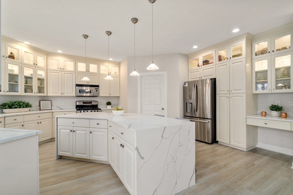 48 Mohawk Path Holliston, MA 01746 - Photo 7 of 41 a kitchen with white cabinets and stainless steel appliances