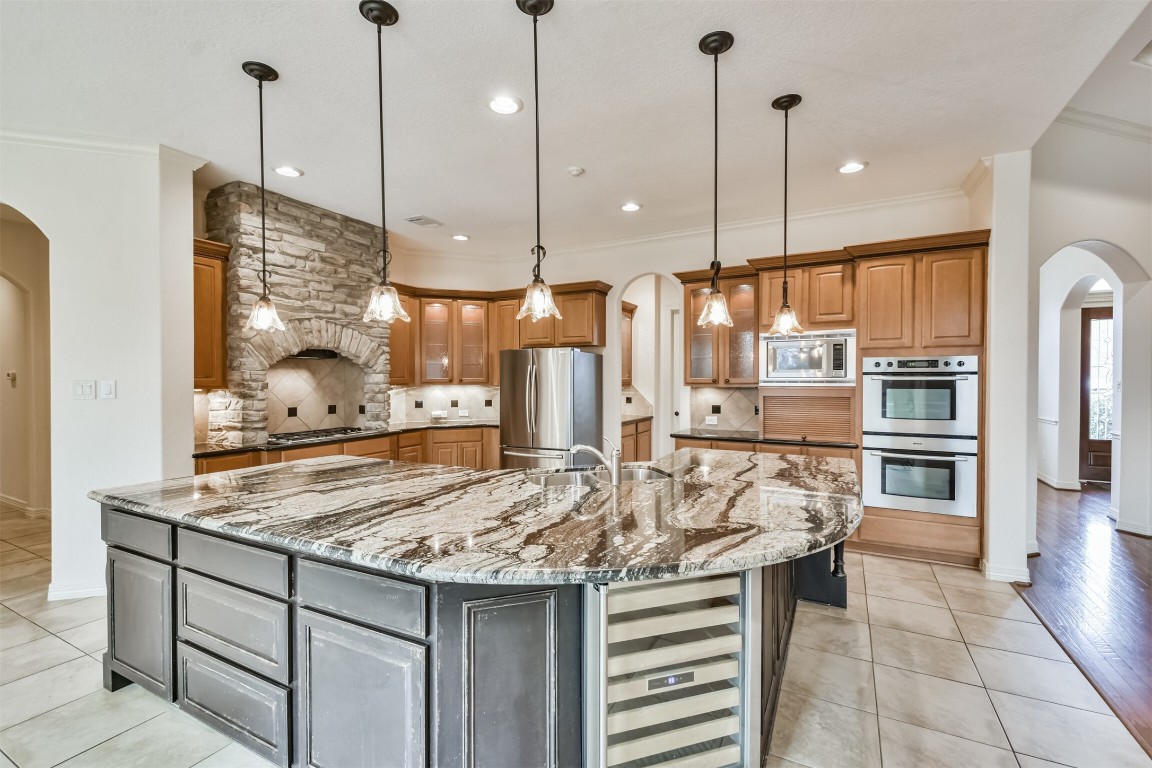 2 Sagestone Conroe, TX 77304 - Photo 12 of 50 a kitchen with stainless steel appliances granite countertop a stove a refrigerator and a wooden cabinets