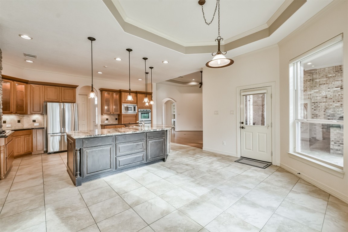 2 Sagestone Conroe, TX 77304 - Photo 17 of 50 a large kitchen with granite countertop a stove a sink a oven and a refrigerator