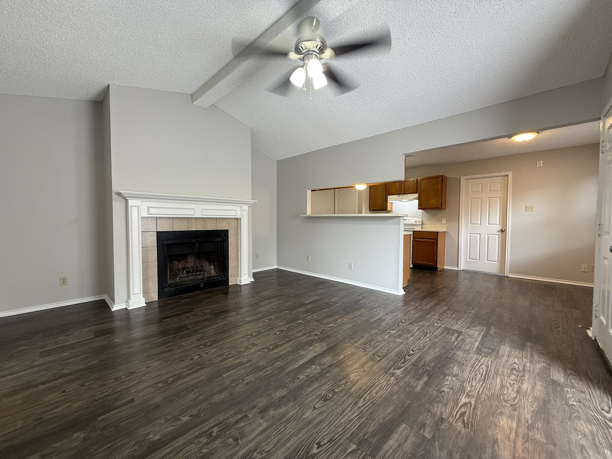 522 Cutty Trail, Unit B Lakeway, TX 78734 - Photo 4 of 20 A welcoming living space features a cozy fireplace and convenient pass-through to the kitchen.