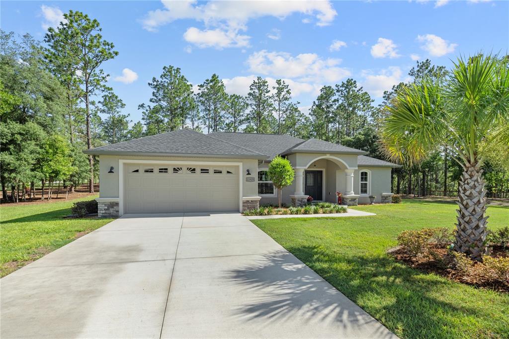 12929 Southwest 89th Street Dunnellon, FL 34432 - Photo 30 of 76 a front view of a house with garden