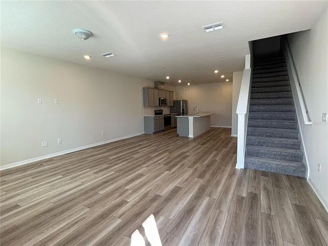 an empty room with wooden floor and entryway