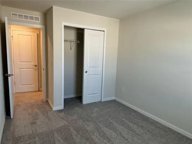 an empty room with closet and a window