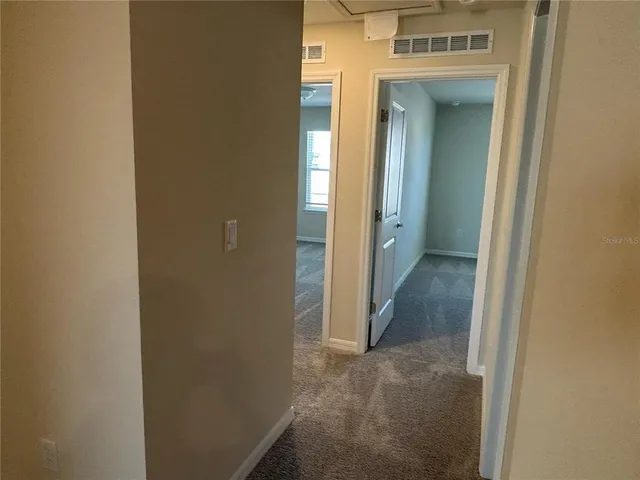 a view of a hallway with wooden shelves