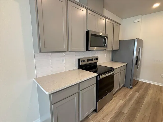 a kitchen with stainless steel appliances a stove microwave and refrigerator