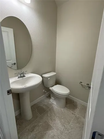 a bathroom with a sink toilet and a mirror