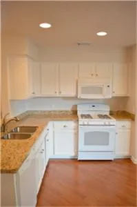 a kitchen with a stove sink and cabinets