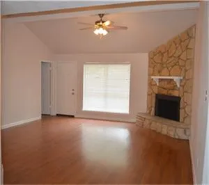an empty room with windows and fireplace