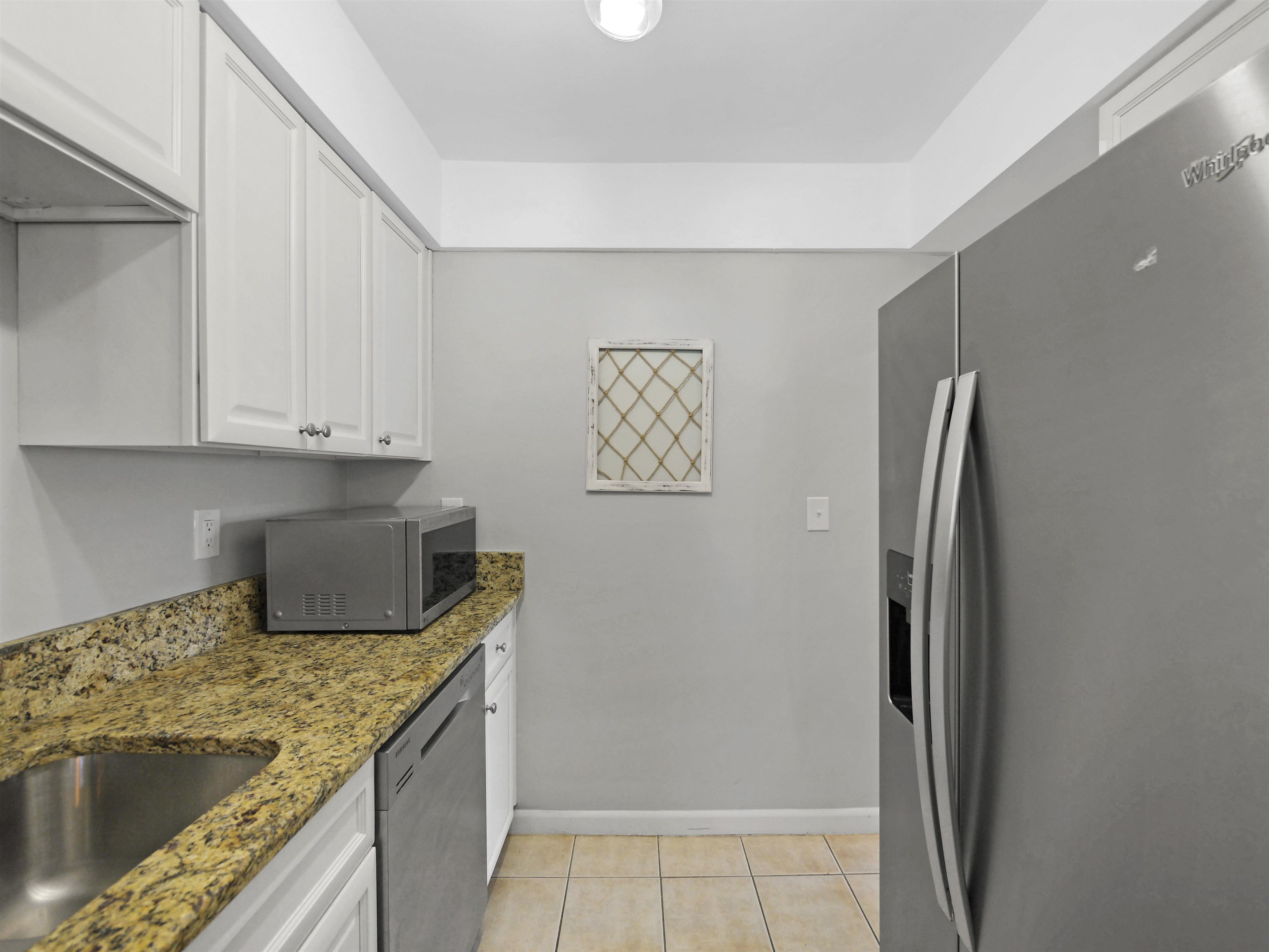 129 Rio Del Mar Street, Unit C St. Augustine, FL 32080 - Photo 12 of 26 a kitchen with stainless steel appliances granite countertop a refrigerator and a sink