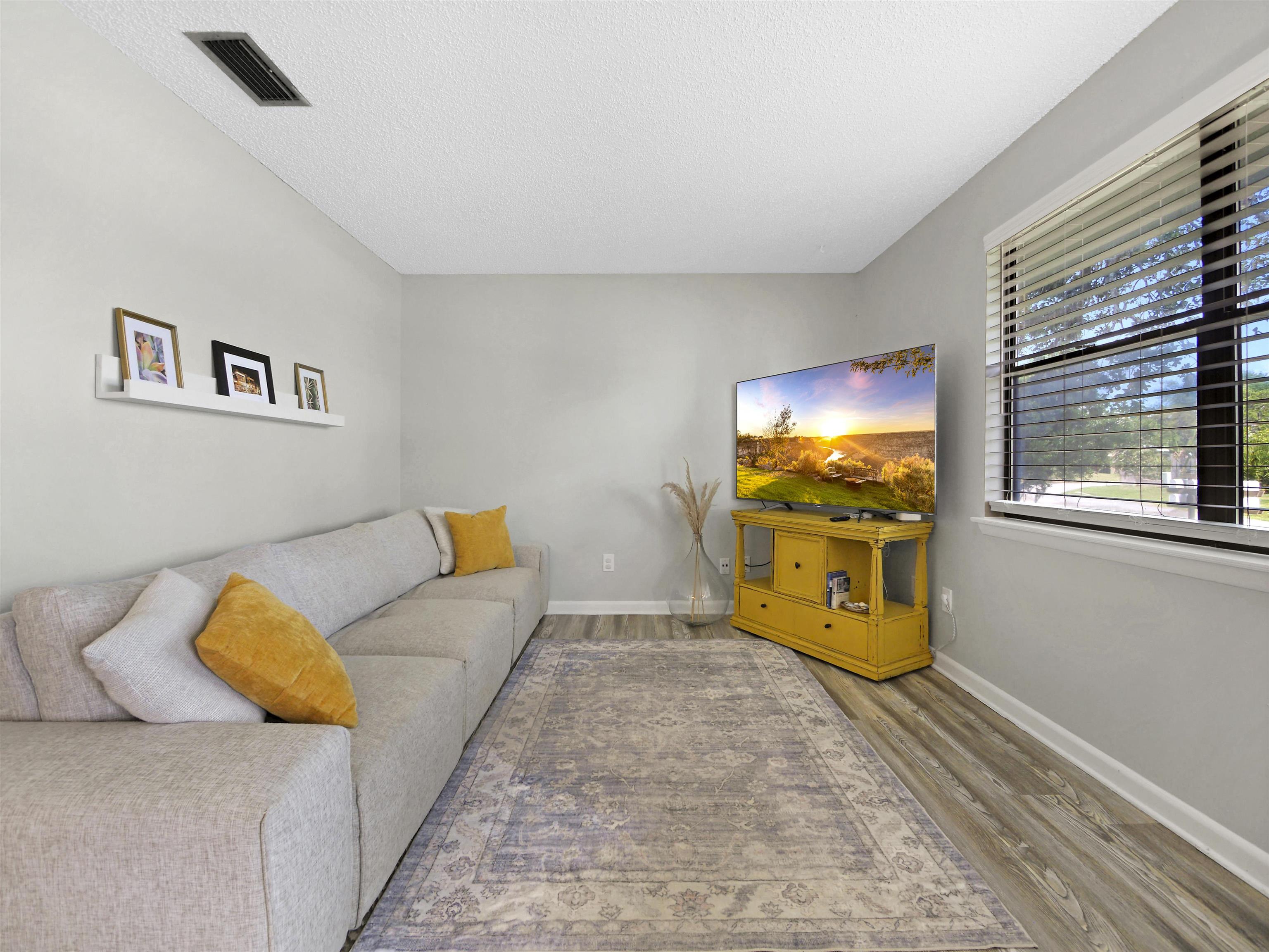 129 Rio Del Mar Street, Unit C St. Augustine, FL 32080 - Photo 6 of 26 a bedroom with a bed and wooden floor