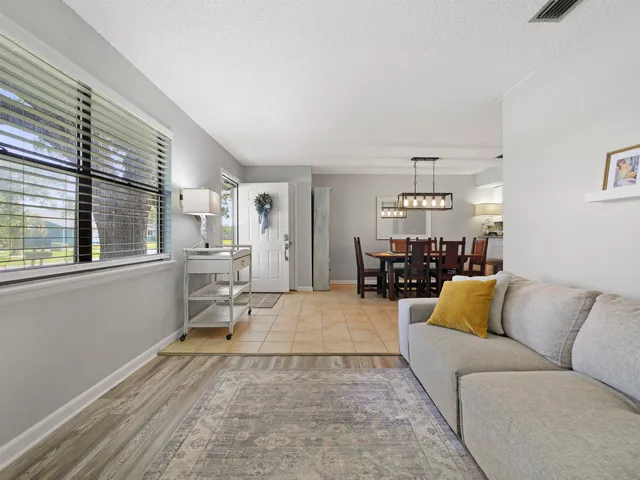 a living room with furniture and view of kitchen
