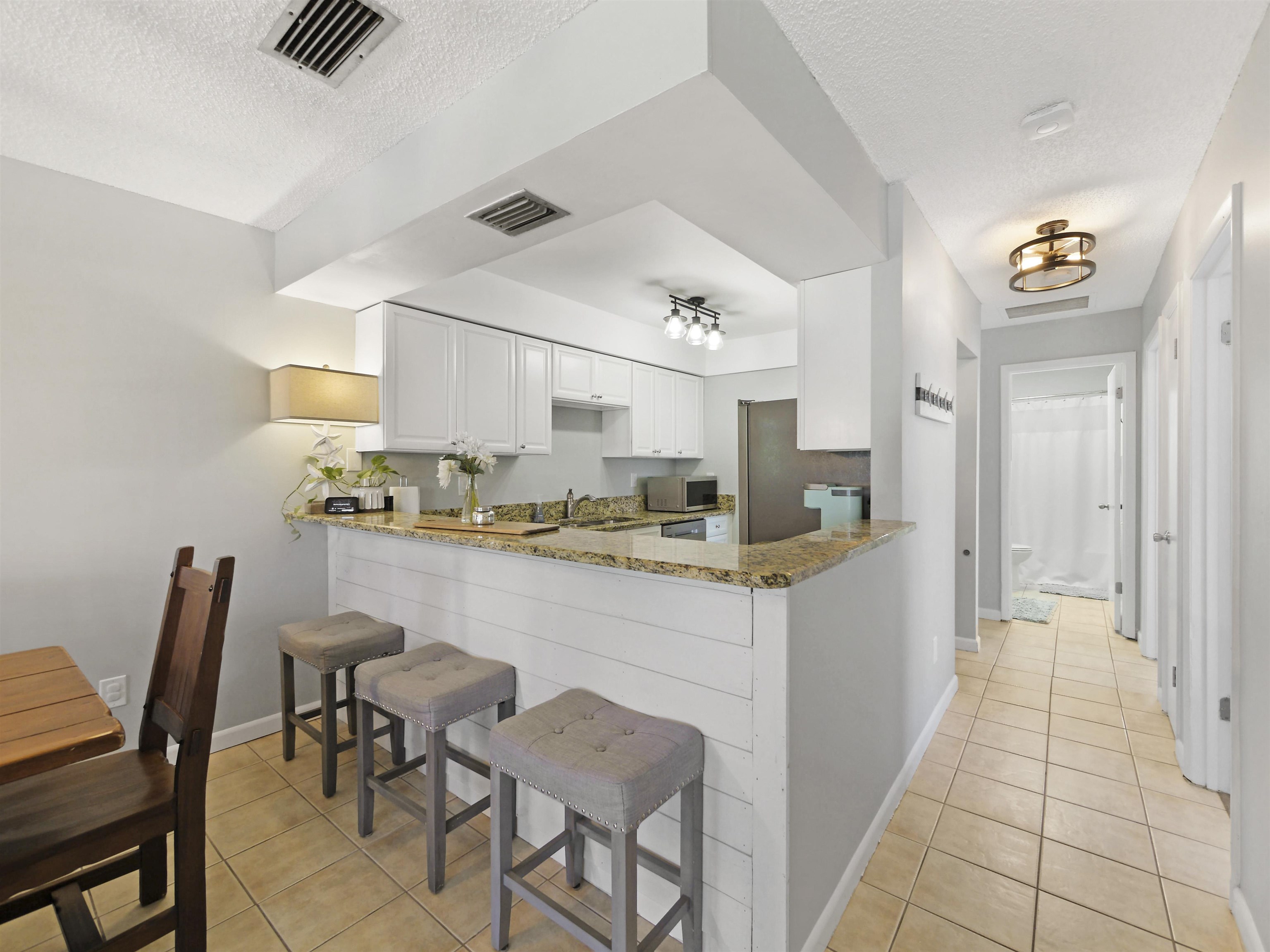 129 Rio Del Mar Street, Unit C St. Augustine, FL 32080 - Photo 9 of 26 a kitchen with stainless steel appliances granite countertop a sink and cabinets