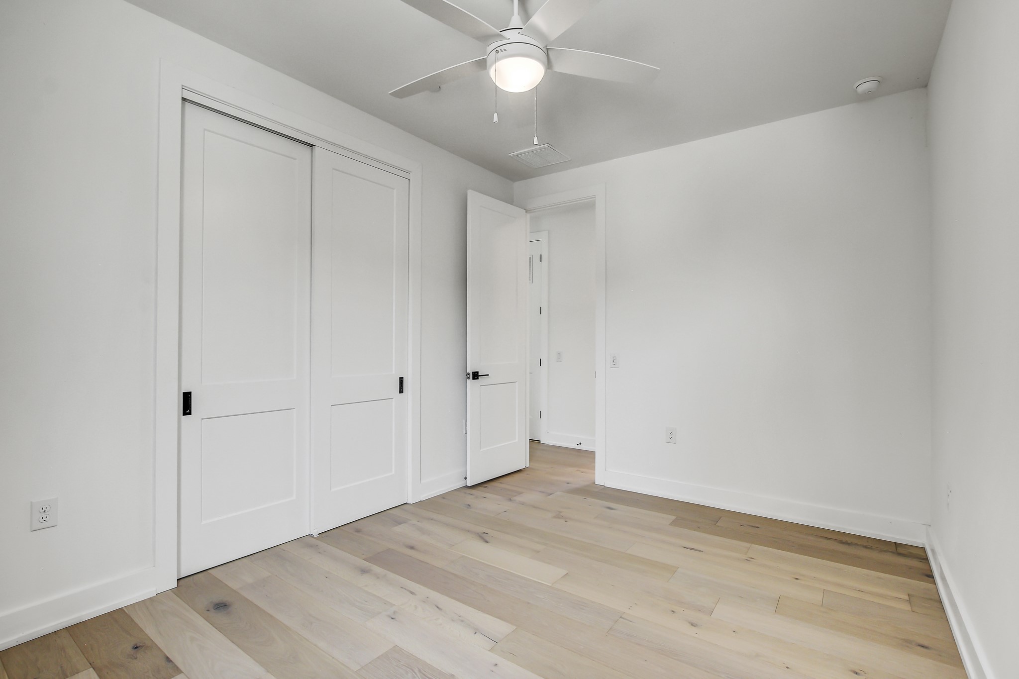 4127 East 12th Street, Unit 3 Austin, TX 78721 - Photo 21 of 29 Unfurnished bedroom with light wood-style flooring, baseboards, a closet, and a ceiling fan