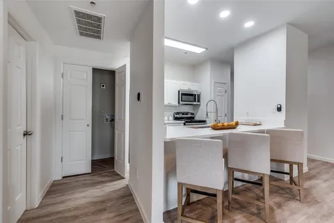 a kitchen with a table chairs refrigerator and cabinets