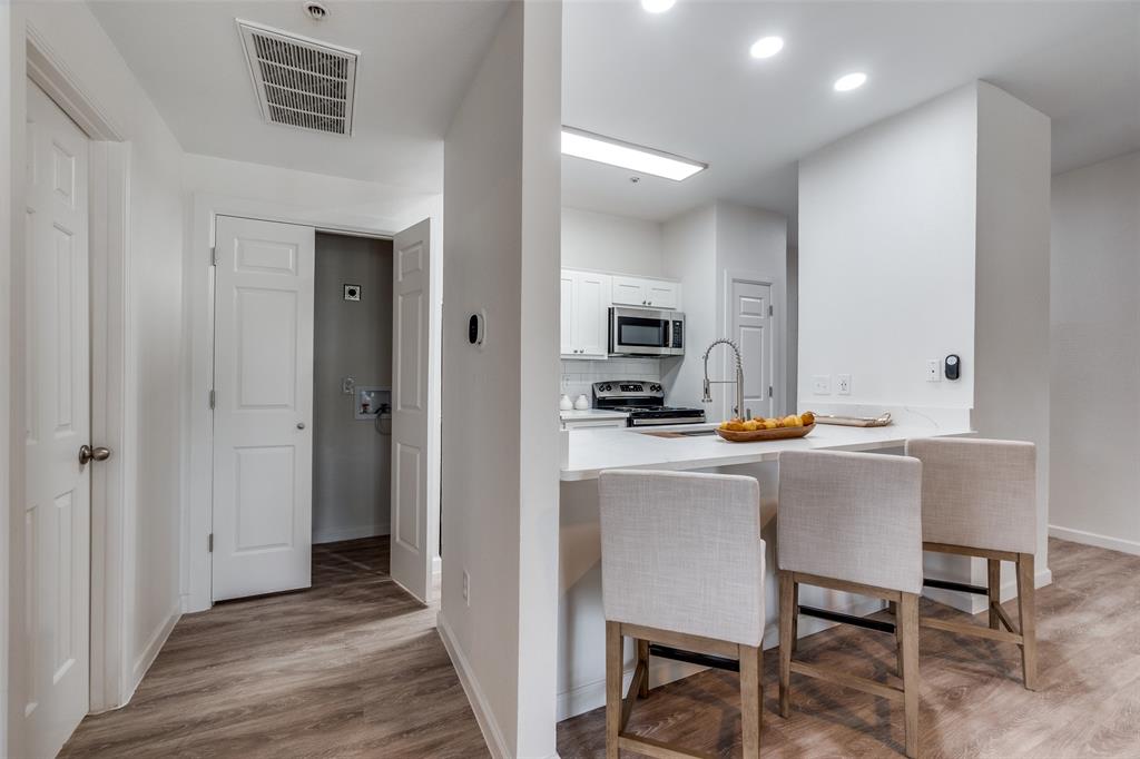 6003 Oram Street, Unit 203 Dallas, TX 75206 - Photo 11 of 25 a kitchen with a table chairs refrigerator and cabinets