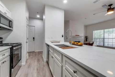 a kitchen with a sink a stove and cabinets