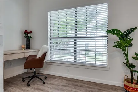 a view of a workspace with furniture and a window