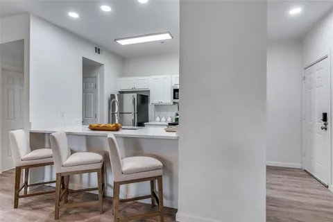 a room with a table chairs and wooden floor