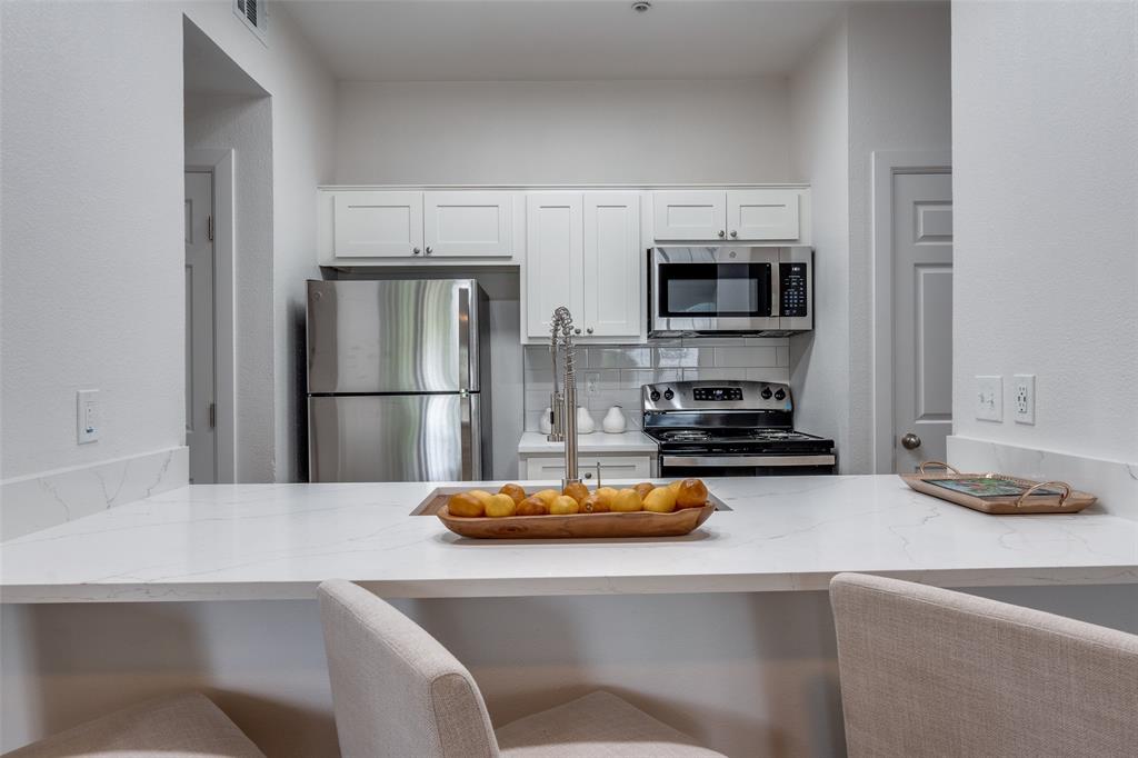 6003 Oram Street, Unit 203 Dallas, TX 75206 - Photo 9 of 25 a kitchen with a refrigerator and a stove top oven