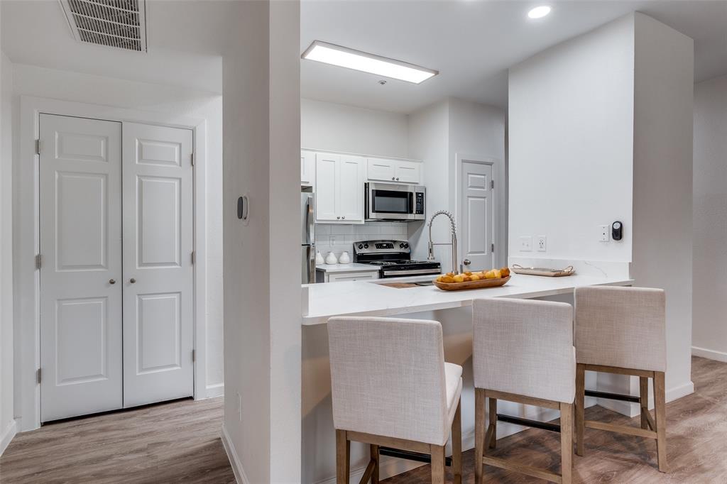 6003 Oram Street, Unit 203 Dallas, TX 75206 - Photo 10 of 25 a kitchen with a dining table chairs and refrigerator