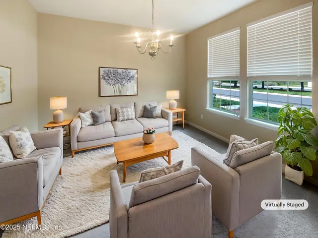 a living room with furniture and a chandelier
