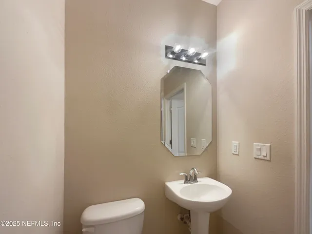 a bathroom with a toilet a sink and mirror